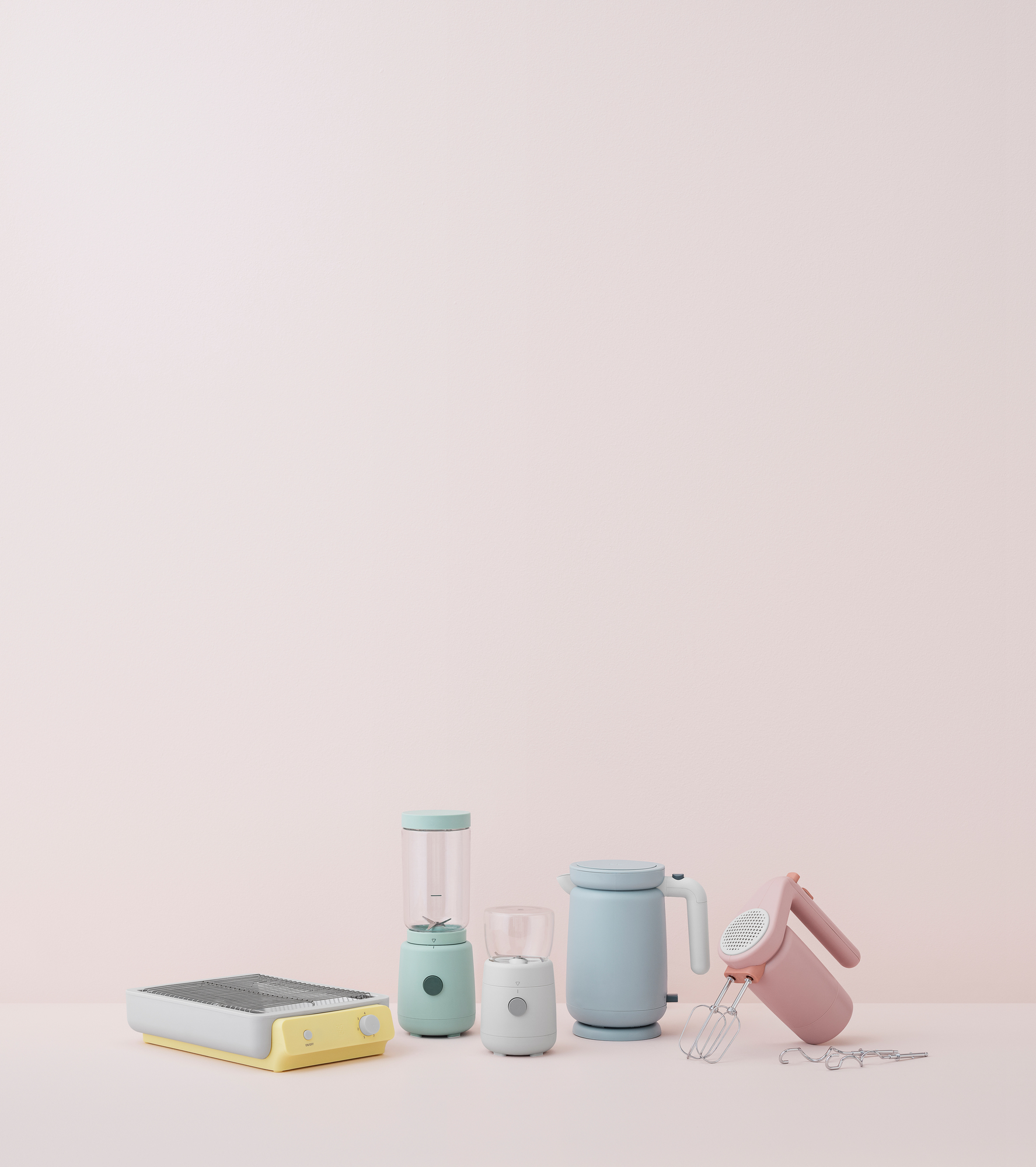 Hellrosa Handrührgerät von RIG TIG by Stelton, Küchengeräte in Pastellfarben auf rosa Hintergrund.