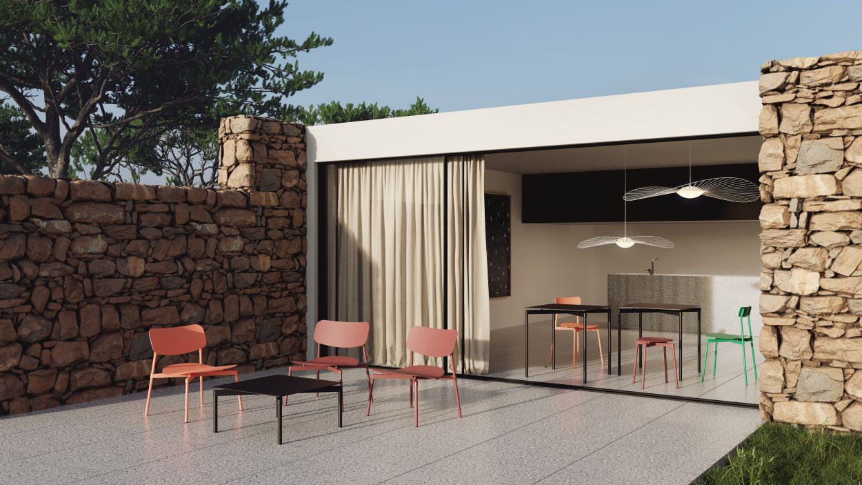 Schwarzer Fromme Coffee Table Couchtisch von Petite Friture mit Stühlen auf einer Terrasse mit Steinmauer.