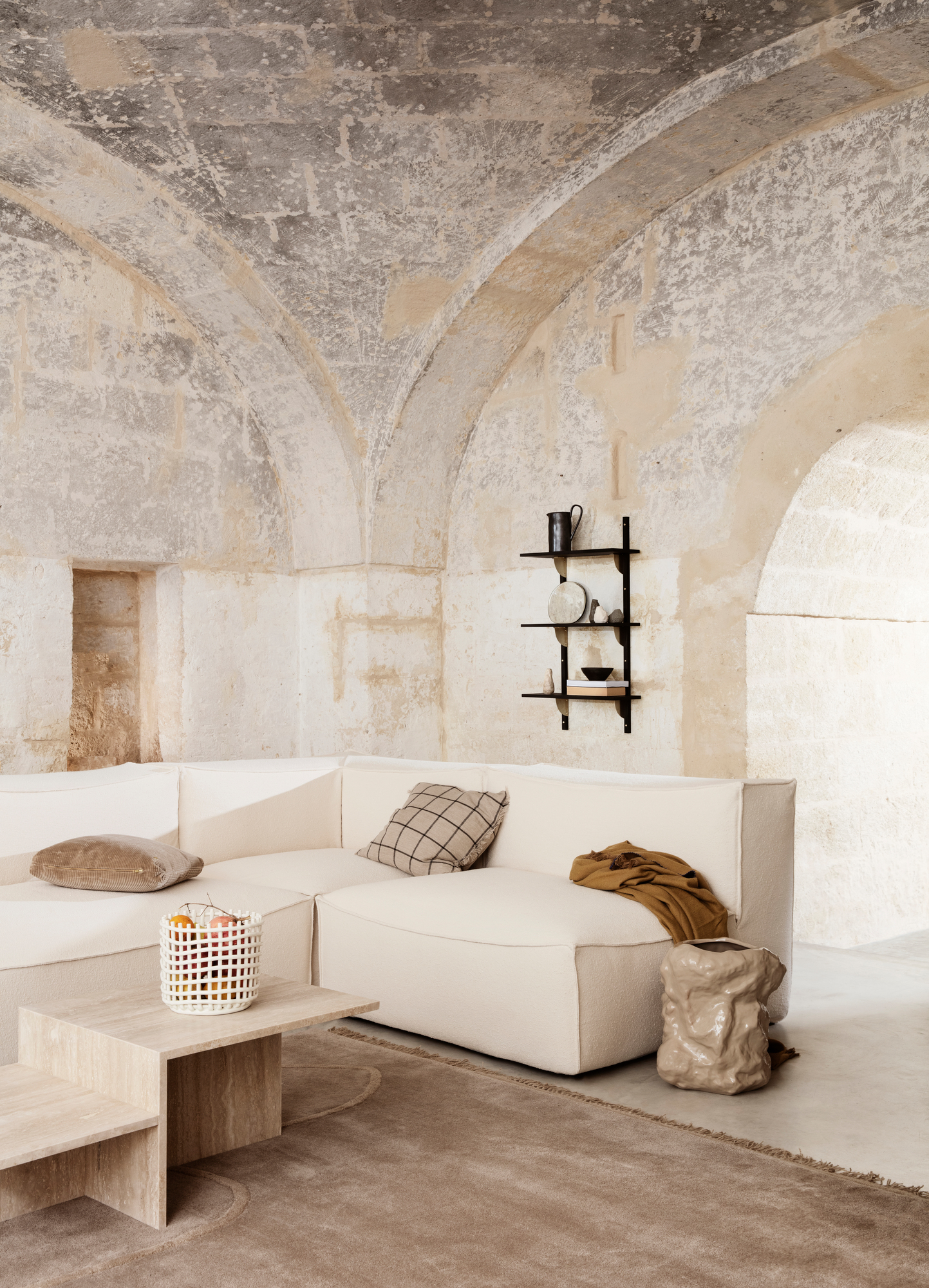 Distinct Couchtisch aus Travertin von Ferm Living im modernen Wohnzimmer mit Sofa und Teppich.