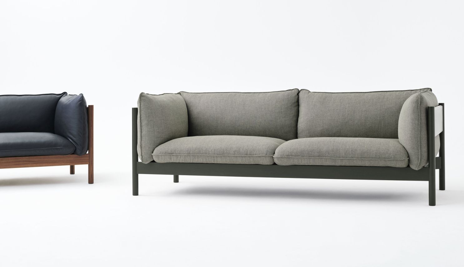 Arbour Sofa von Hay, graues 3-Sitzer-Sofa mit dunklem Holzrahmen auf weißem Hintergrund.
