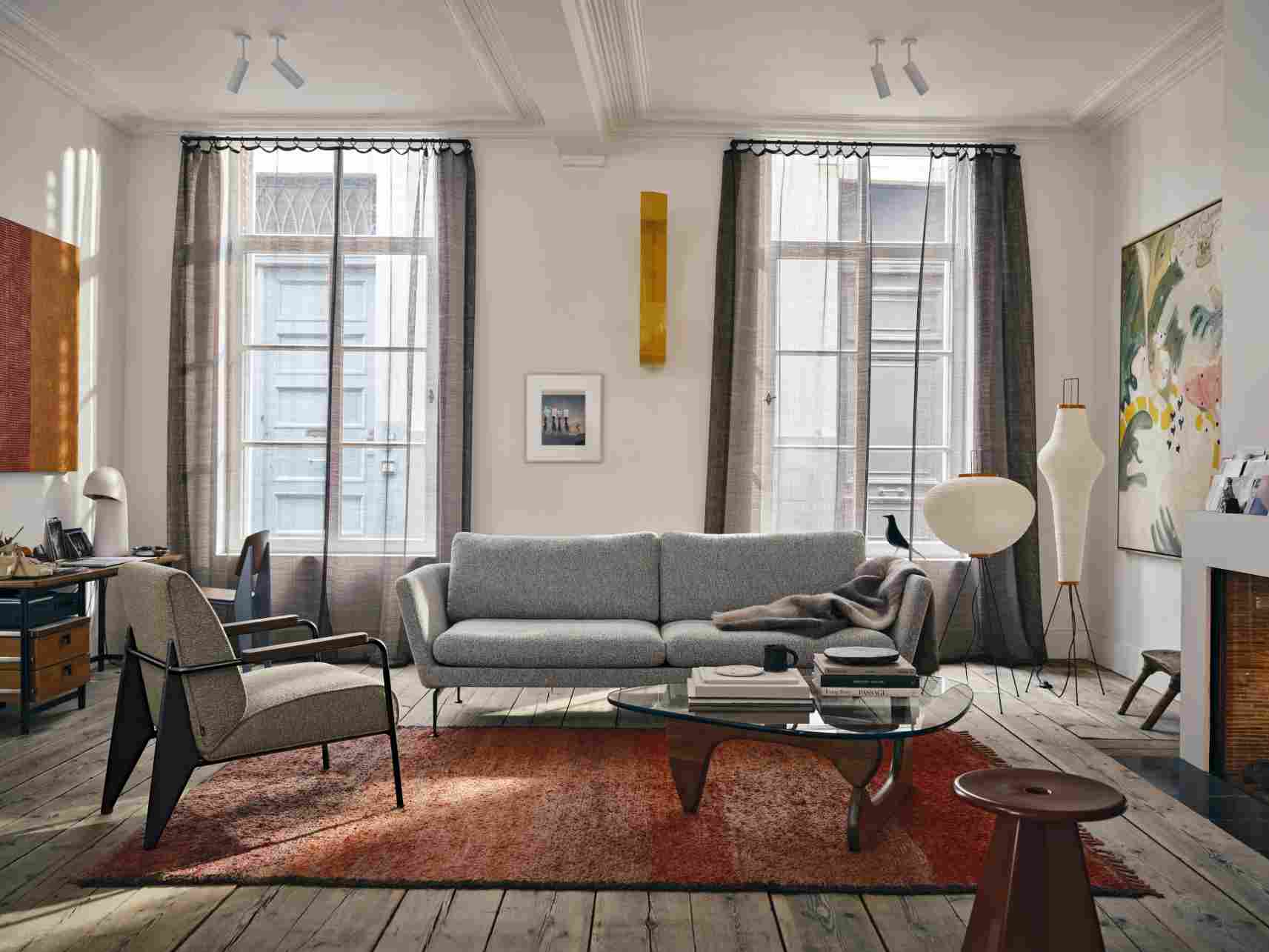 Wohnzimmer-Szene mit Vitra Tabouret Métallique Hocker aus Holz, neben einem Teppich.