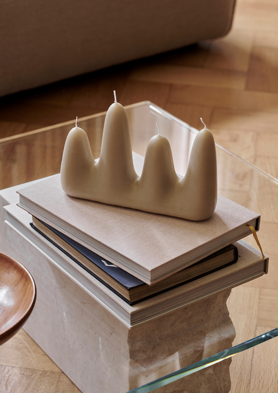 Beige Stala Candle Kerze von Ferm Living auf einem Bücherstapel, moderne Wohnraumdekoration.