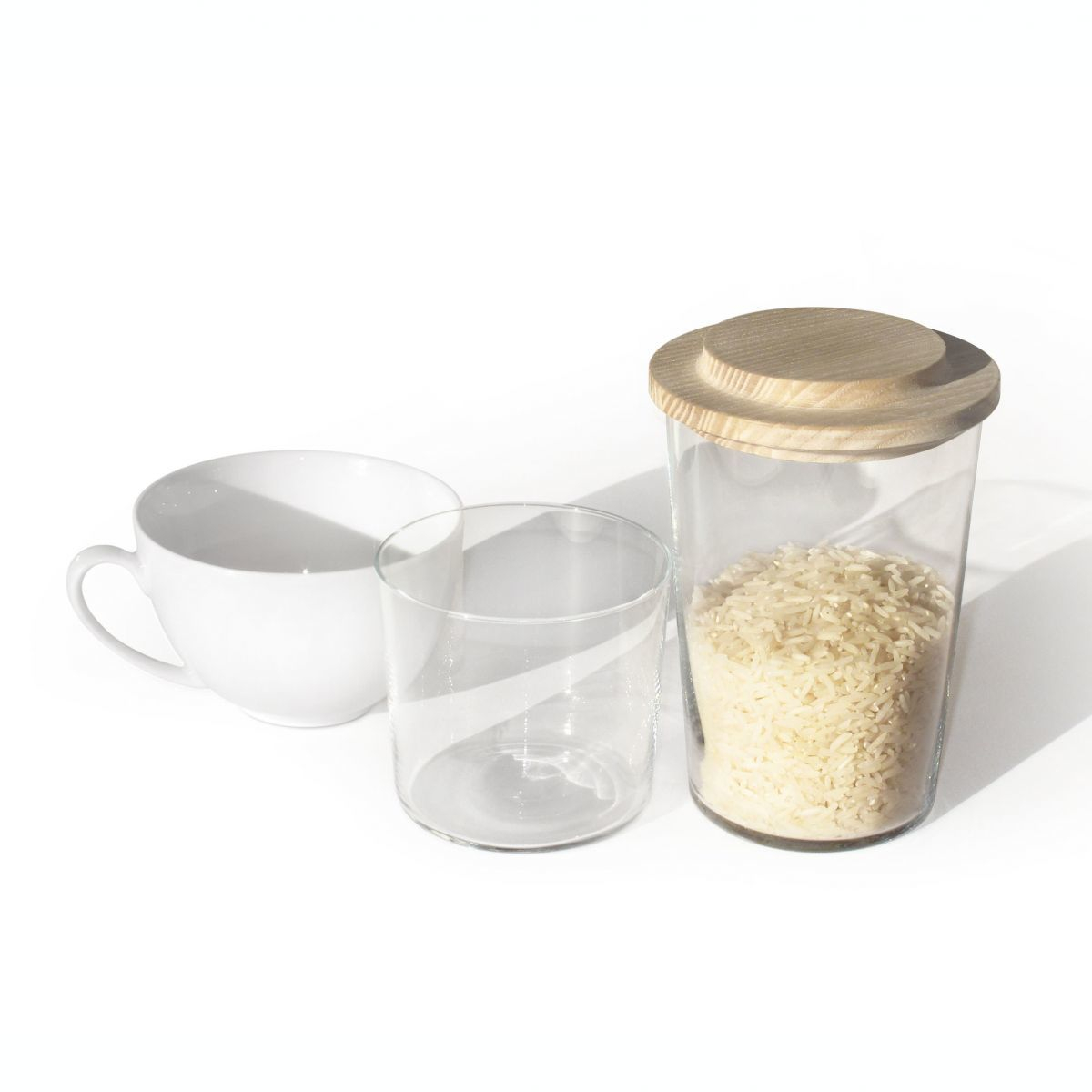 Glasbehälter mit Reis und OH, GUT Holzdeckel, neben Tasse und Glas.