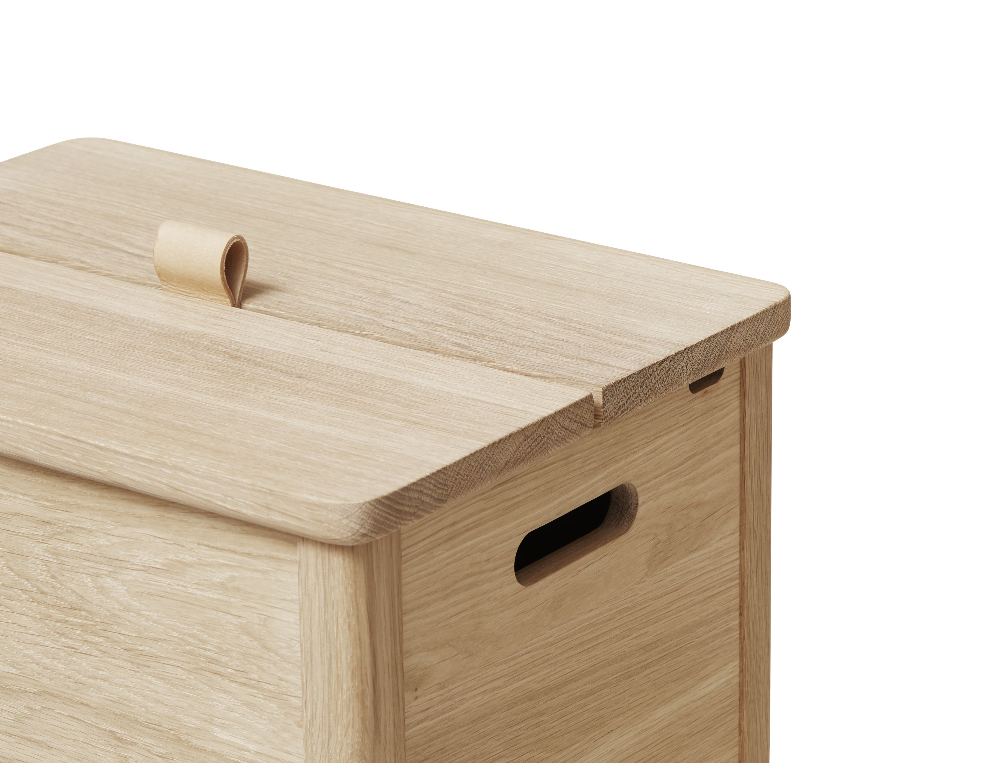 Detailaufnahme: A Line Wäschekasten aus Eiche, weiß geölt, mit Ledergriff und Griffloch.