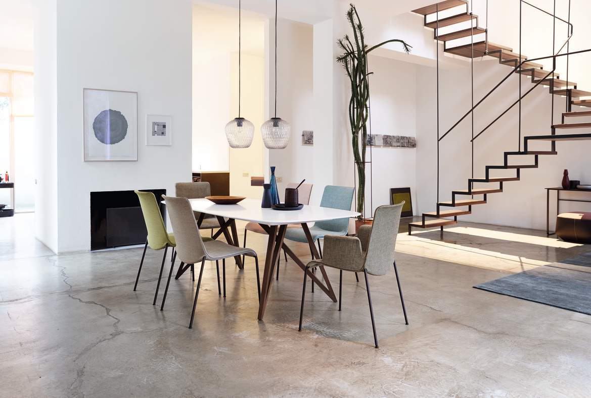 Esszimmer mit Seito Tisch von Walter Knoll, weißen Wänden und moderner Treppe.