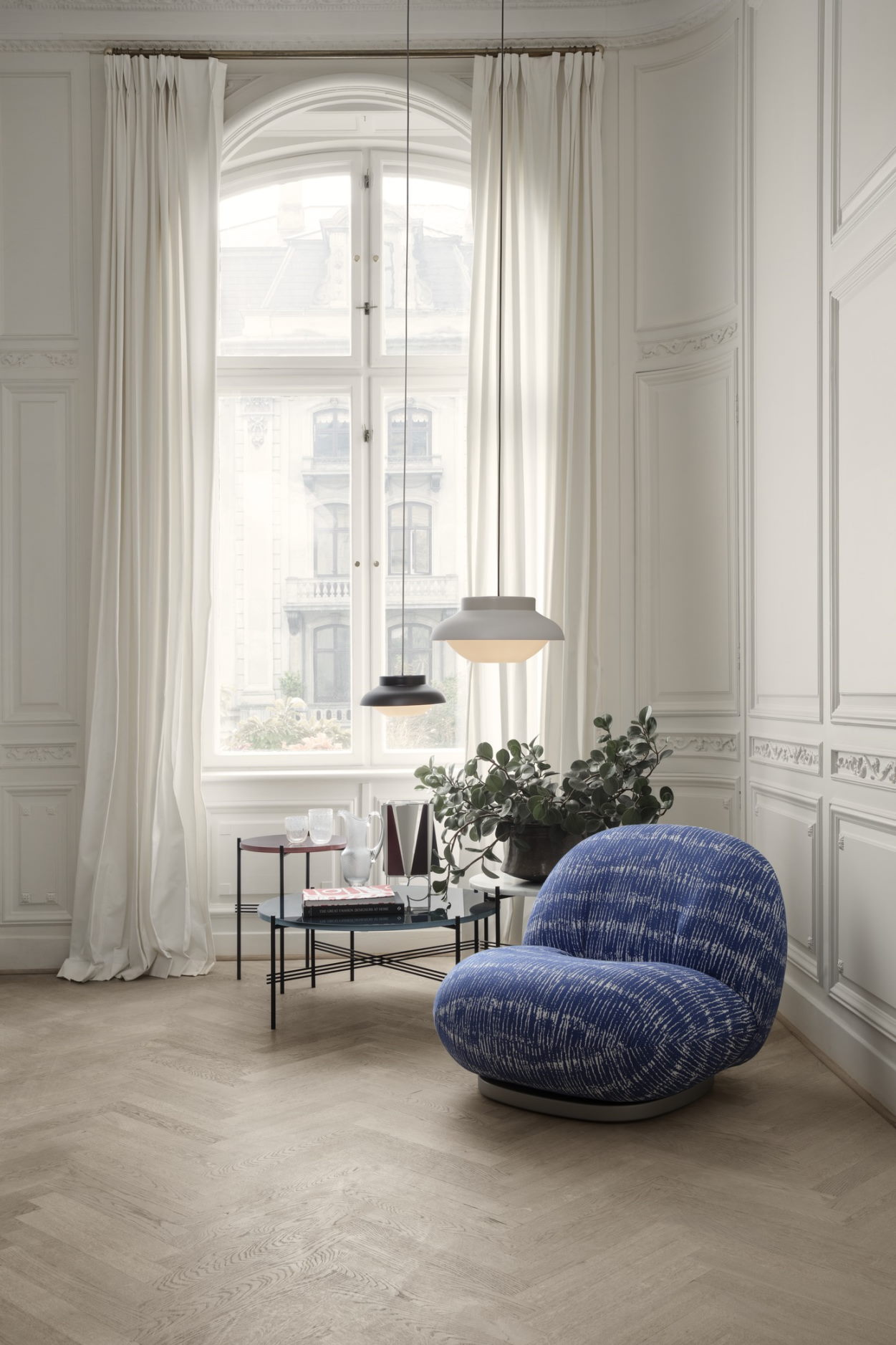 TS Beistelltisch von Gubi mit schwarzer Marmorplatte in stilvollem Wohnzimmerambiente, ergänzt durch Designermöbel und Pendelleuchten.