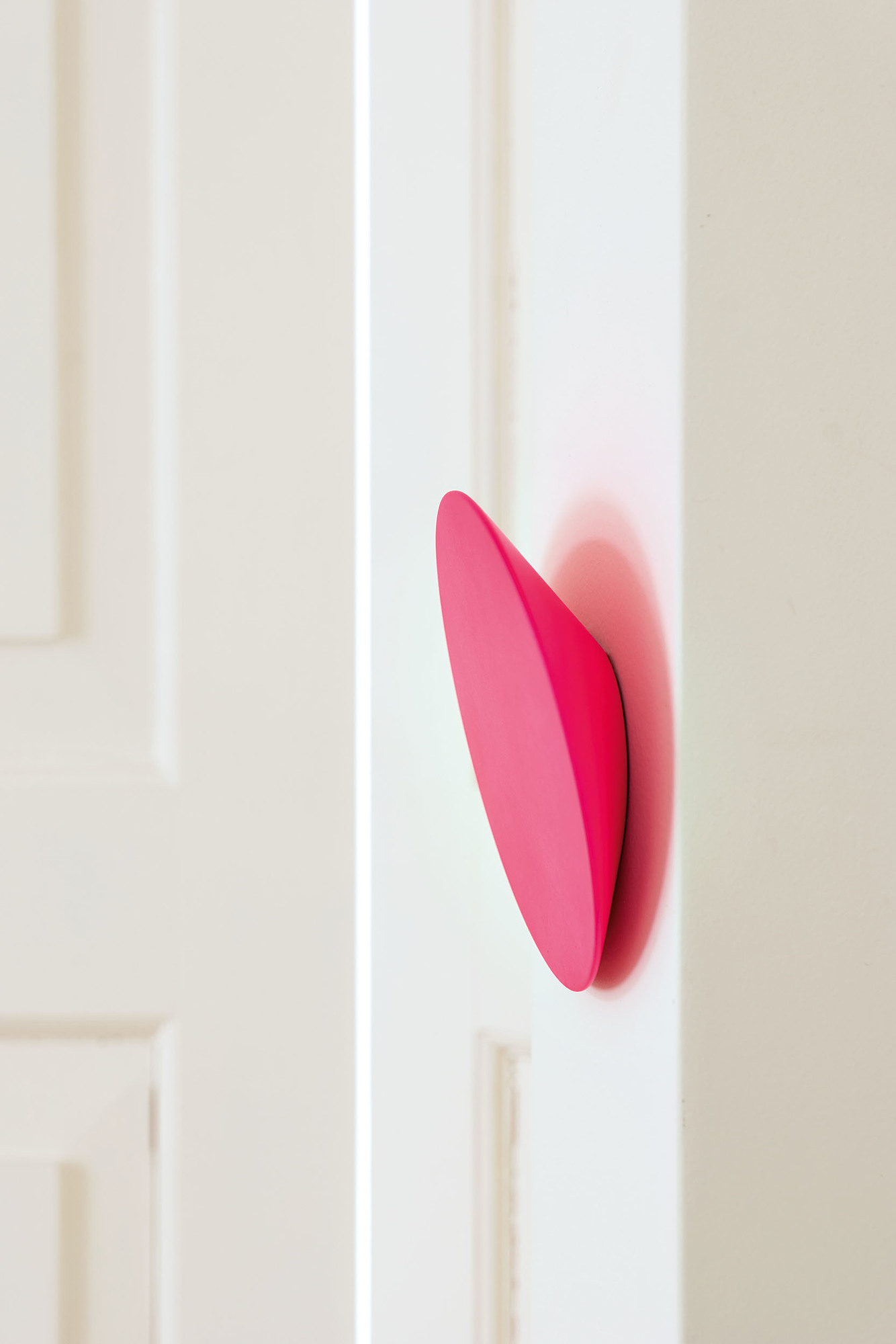 Pinker Schönbuch Disk Wandhaken an einer weißen Wand, moderner Kleiderhaken und Garderobenhaken.