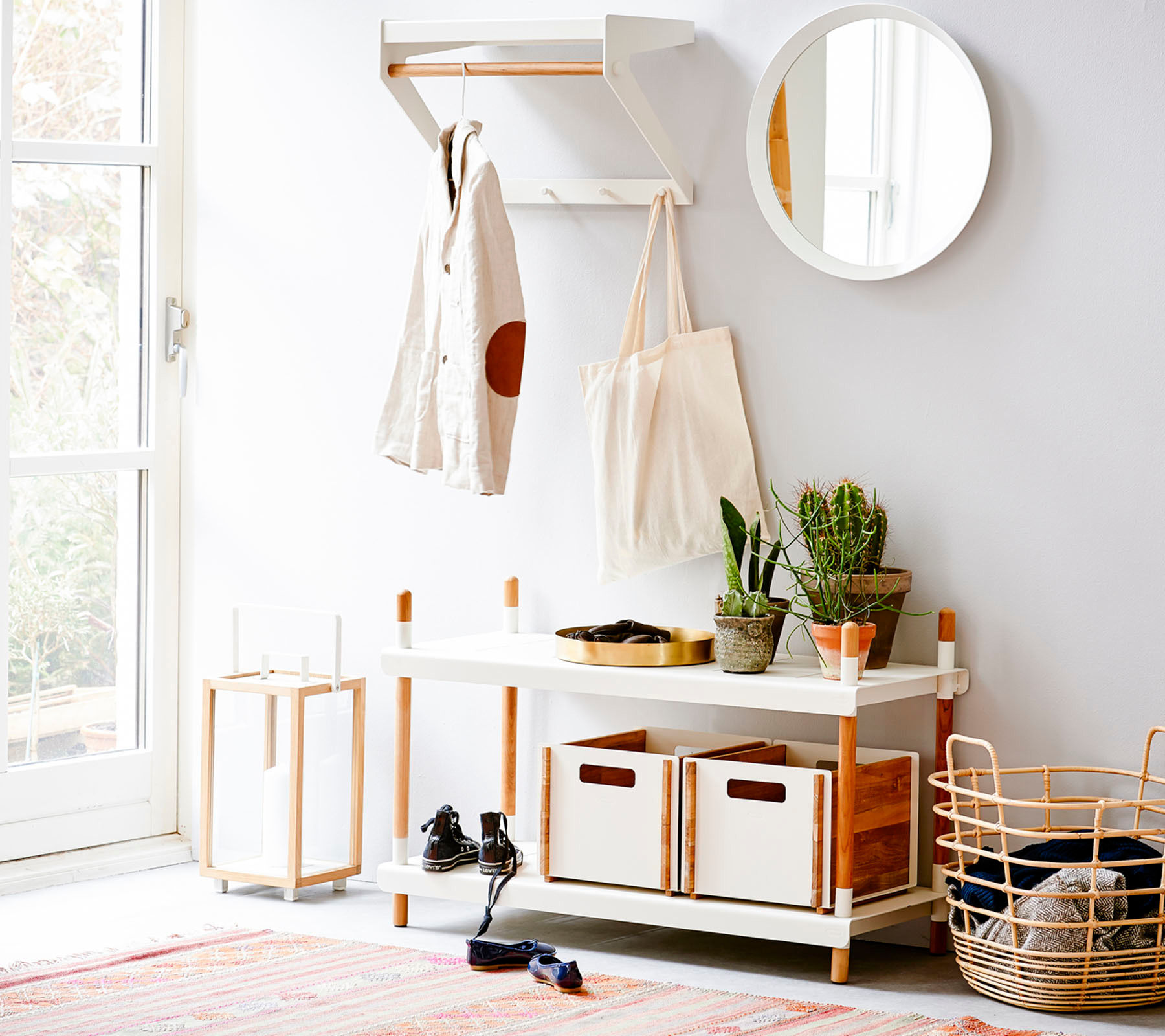 Heller Flur mit Cane-Line City Rack Garderobe, Kleiderstange, Spiegel und Aufbewahrungskörben.