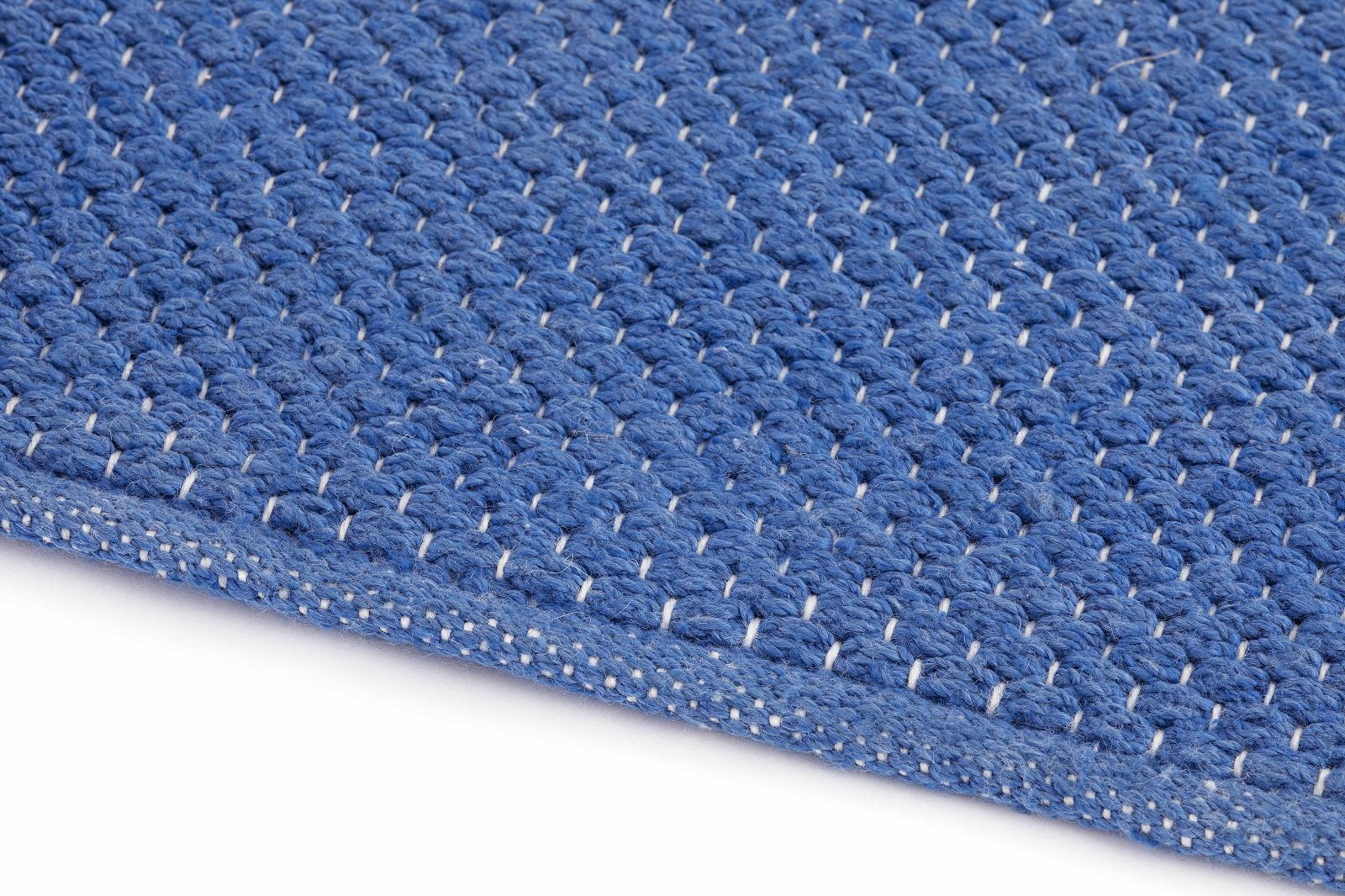 Detailaufnahme des blauen Mangas Outdoor Teppichs Gan mit weißem Muster, ideal für Terrasse und Garten.