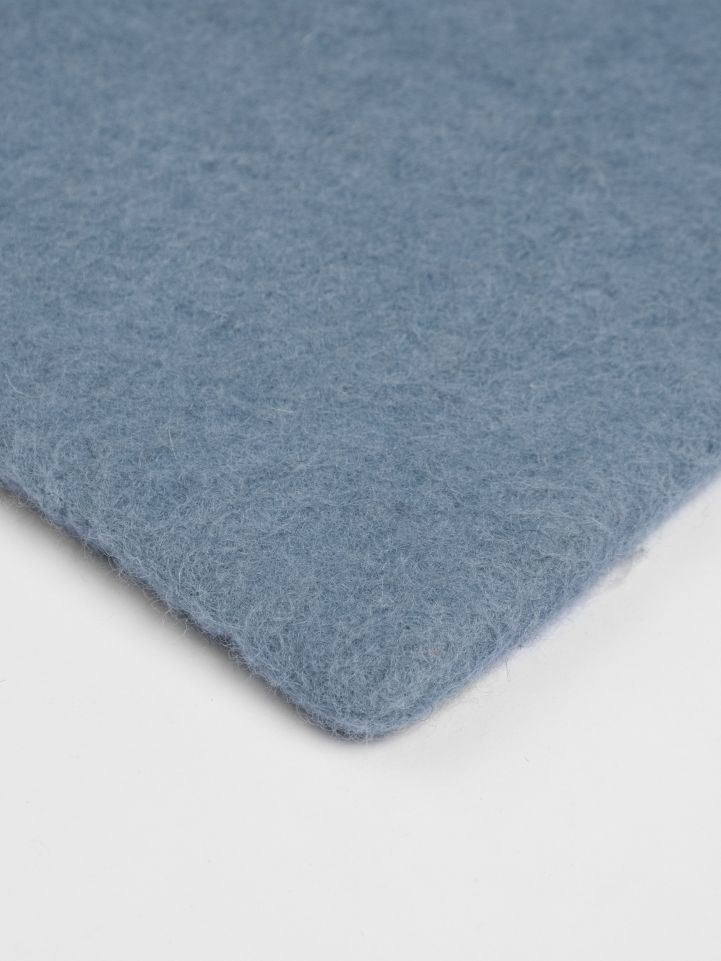 Detailaufnahme des hellblauen myfelt Filzteppichs, rechteckig, für Wohnzimmer und Schlafzimmer.
