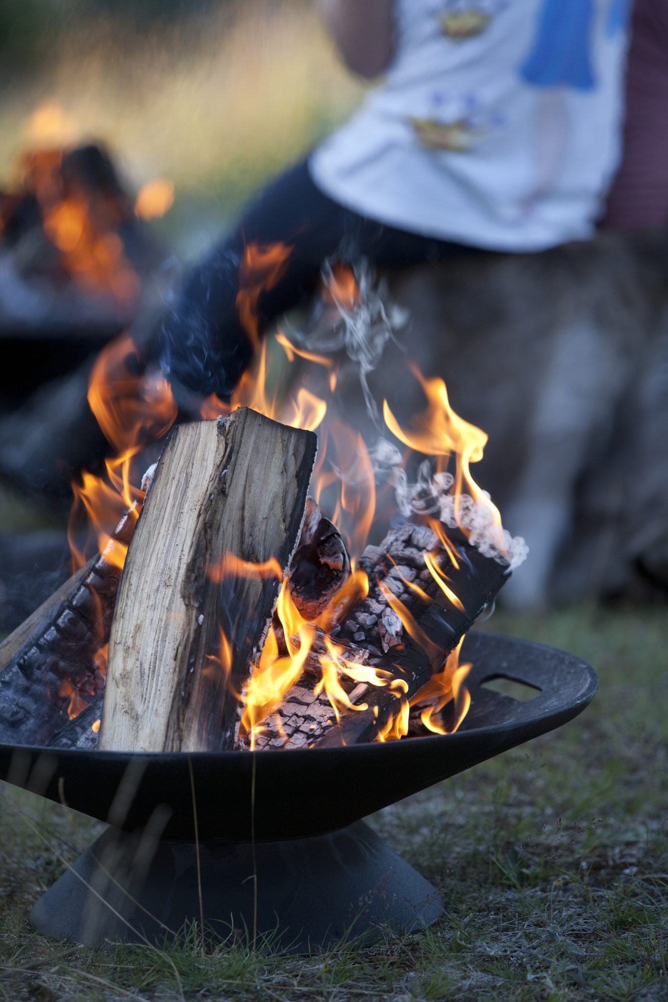 Helios Firebowl Feuerschale: Brennendes Holz in schwarzer Feuerschale für Garten und Terrasse.