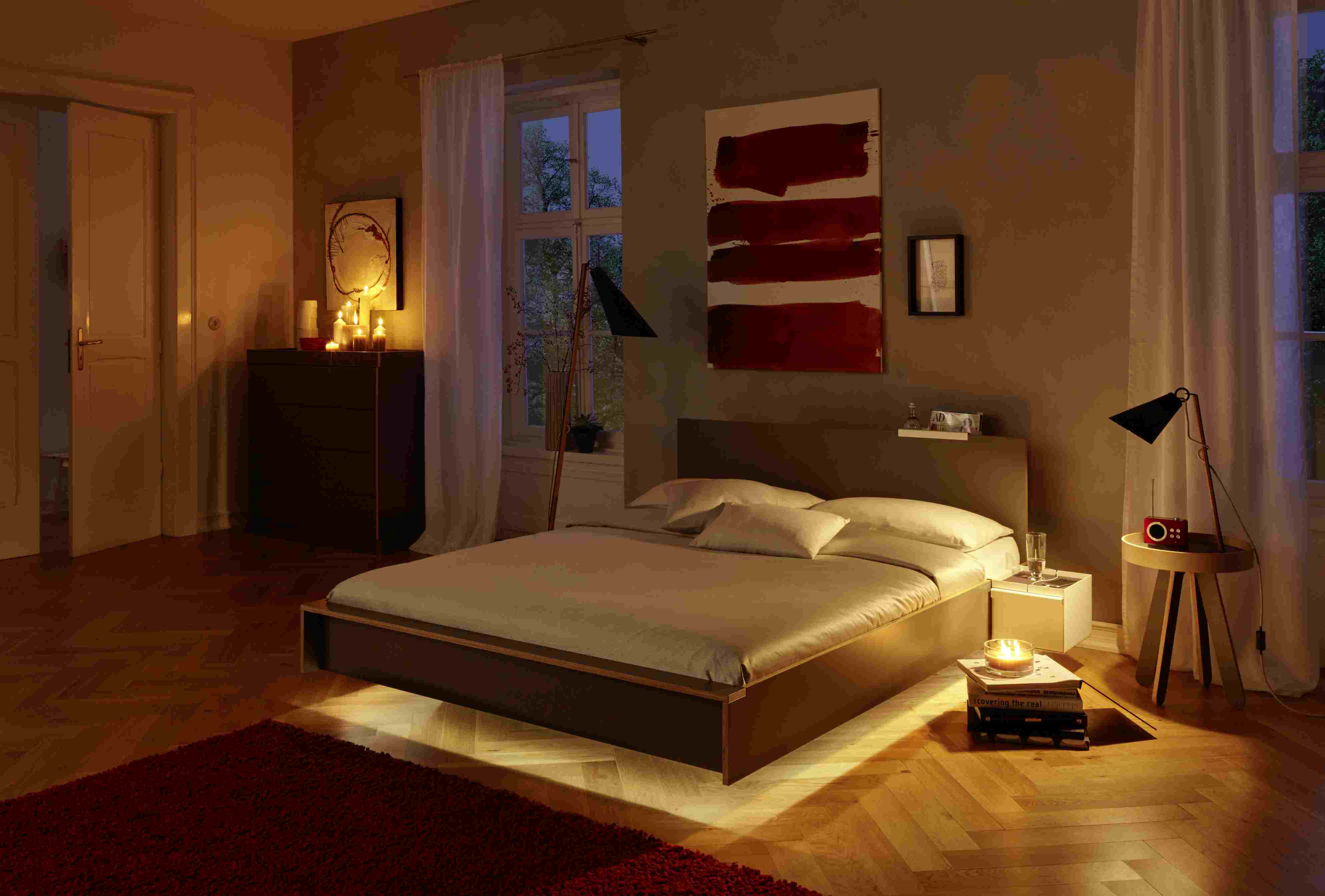 Schlafzimmer mit Flai Bett von Müller Möbelwerkstätten, Kopfteil in Weiß und indirekter Beleuchtung.