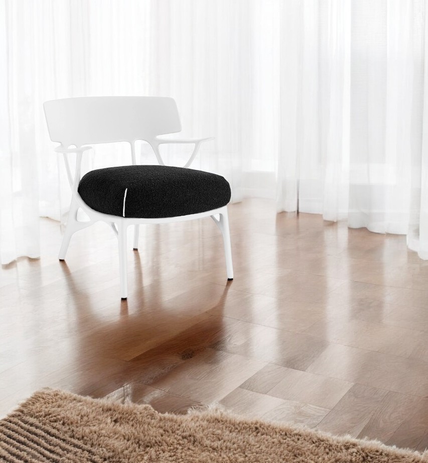 Weißer A.I. Lounge Sessel von Kartell mit schwarzem Sitzkissen vor hellem Hintergrund. Designermöbel für Wohnzimmer.