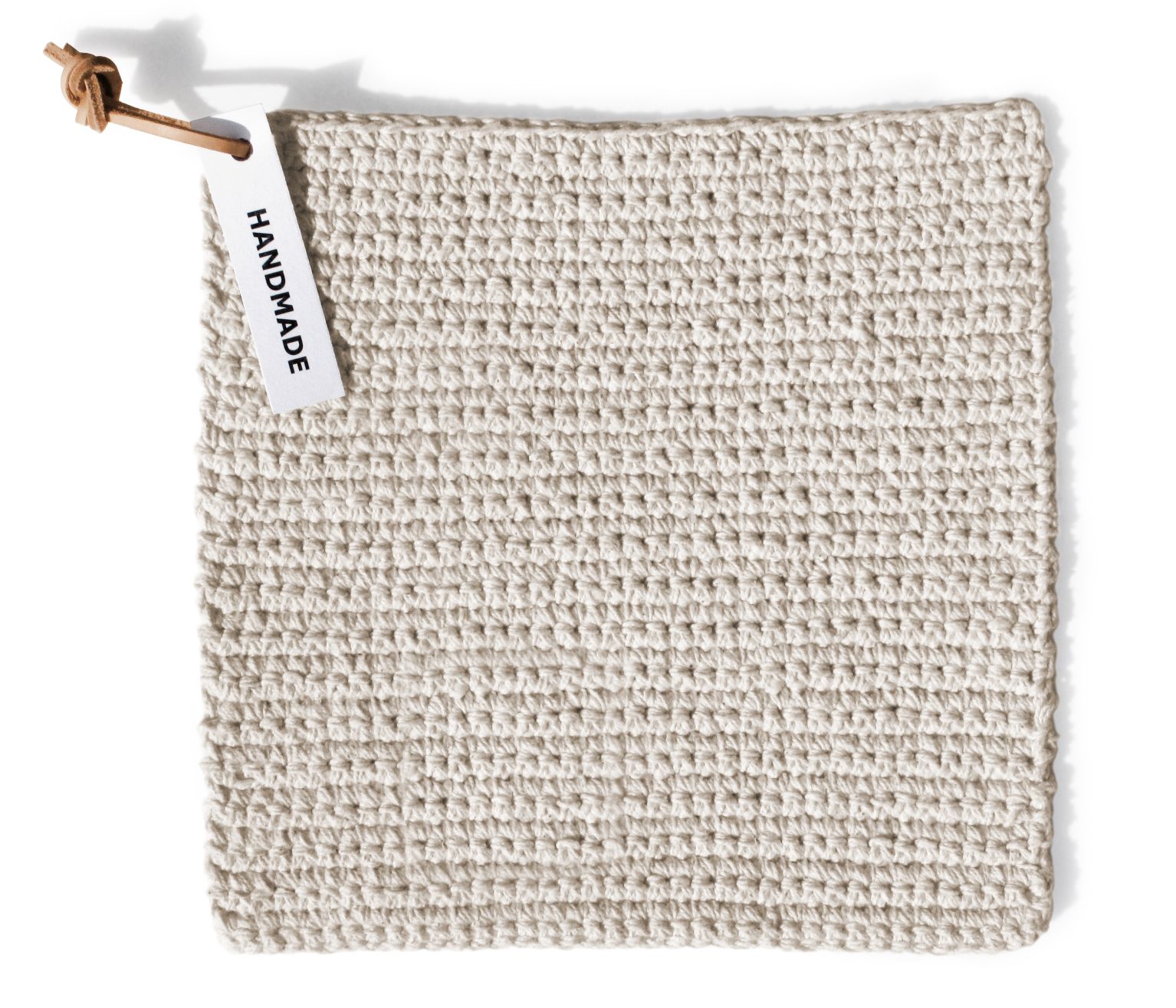 Handgemachter, gehäkelter Topflappen in Beige mit "Handmade"-Etikett, ideal als Küchenaccessoire und Hitzeschutz.