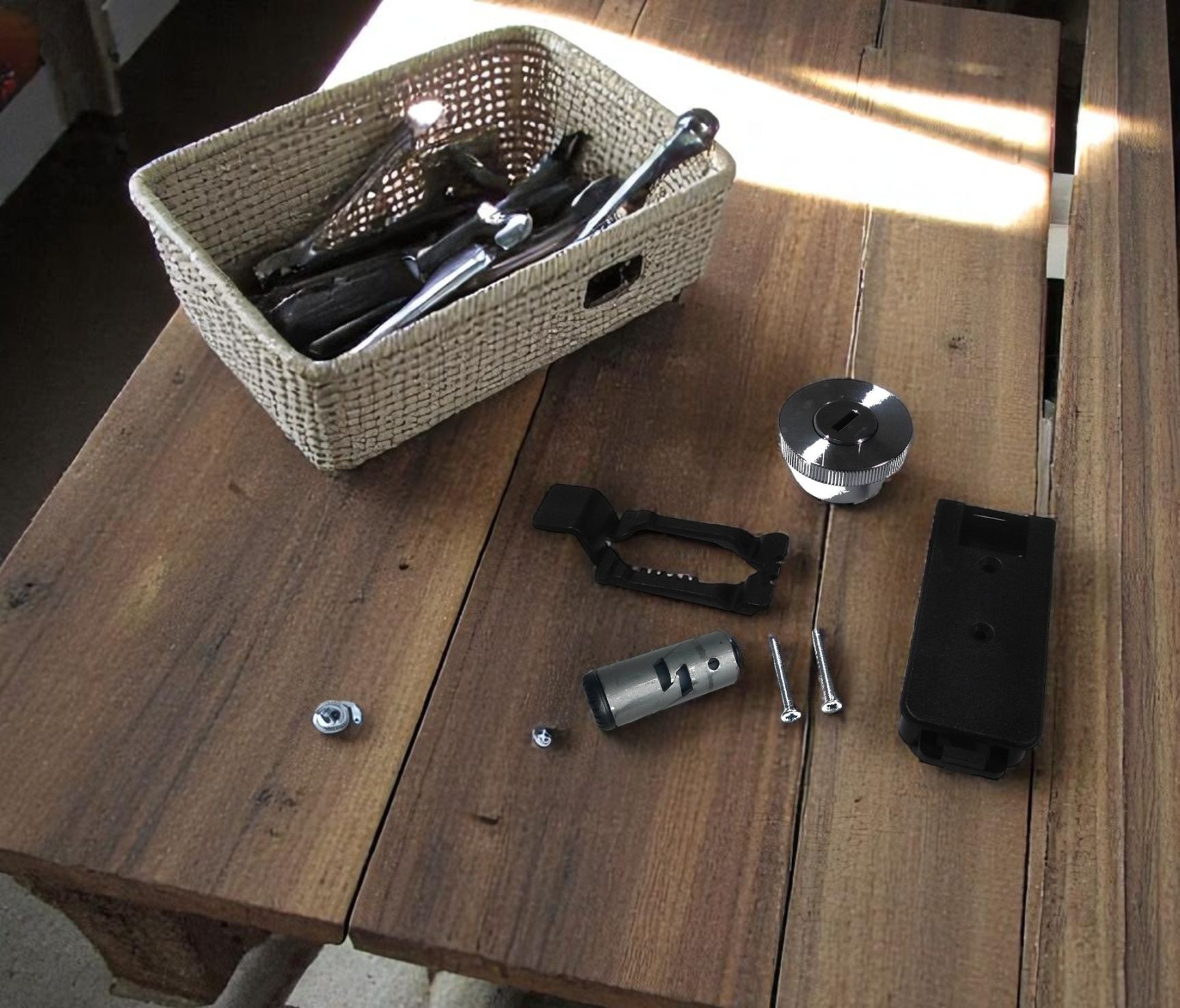Produktbild: Einzelteile für Möbelmontage, Schrauben, Dübel, Werkzeug im Korb auf Holztisch.