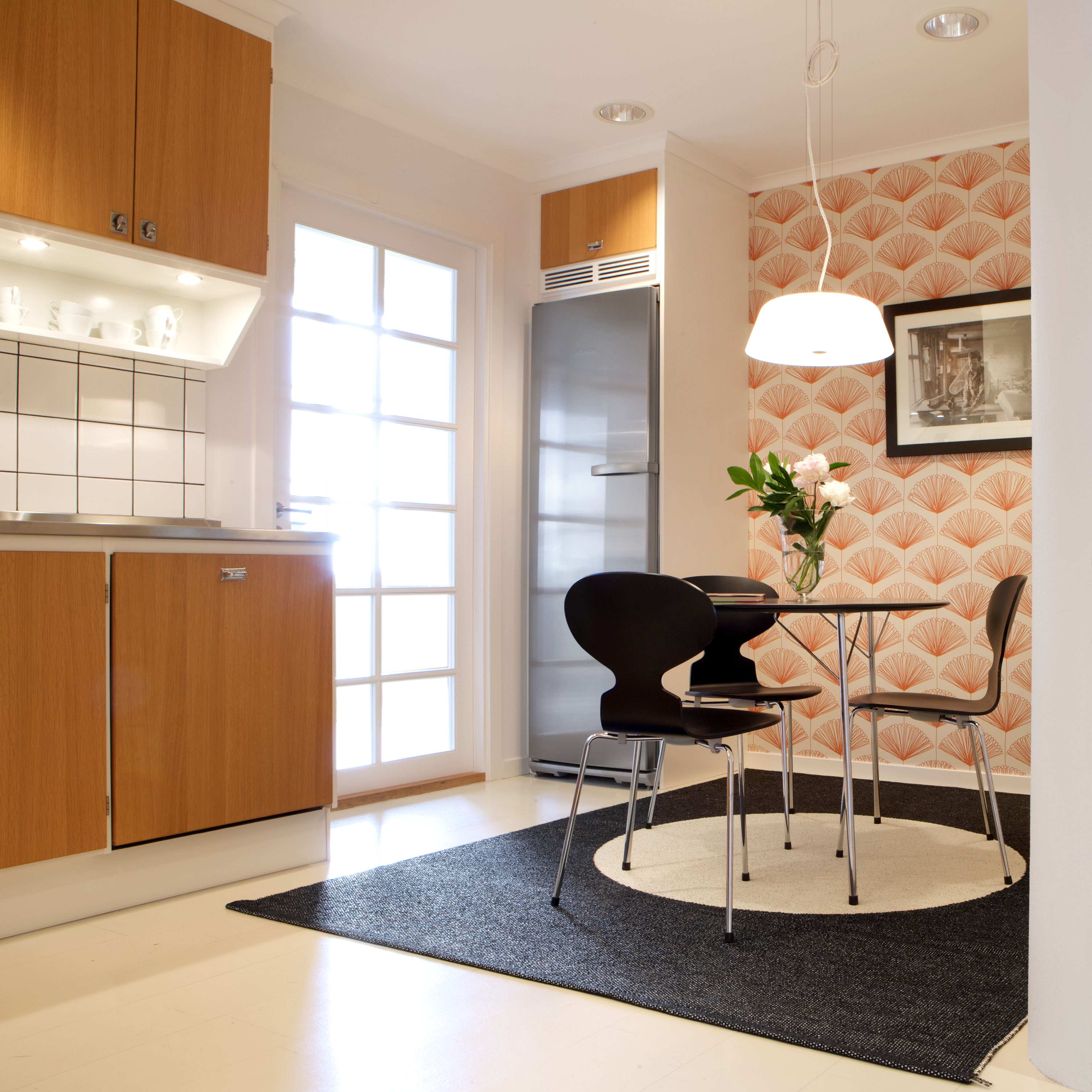 Schwarzer Vera One Pappelina Kunststoffteppich 180x230 cm unter Esstisch in modernem Küchendesign. Robuster, pflegeleichter Teppich für Innen und Außen.