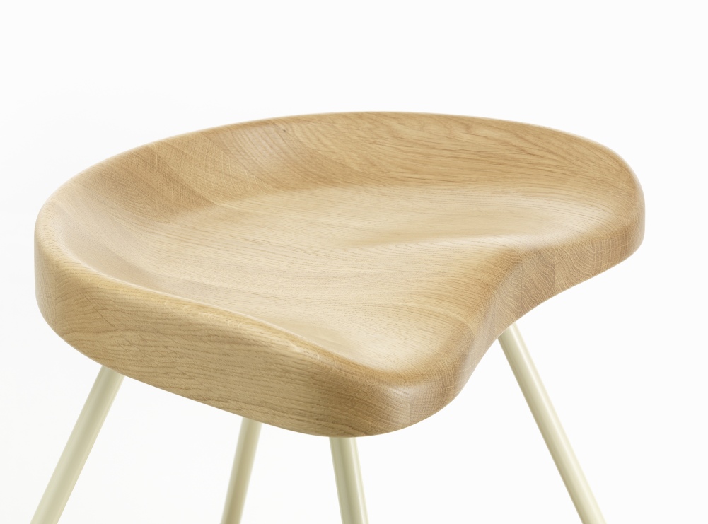 Nahaufnahme: Tabouret Hocker mit hellem Holz-Sitz und filigranem Metallgestell von Vitra.
