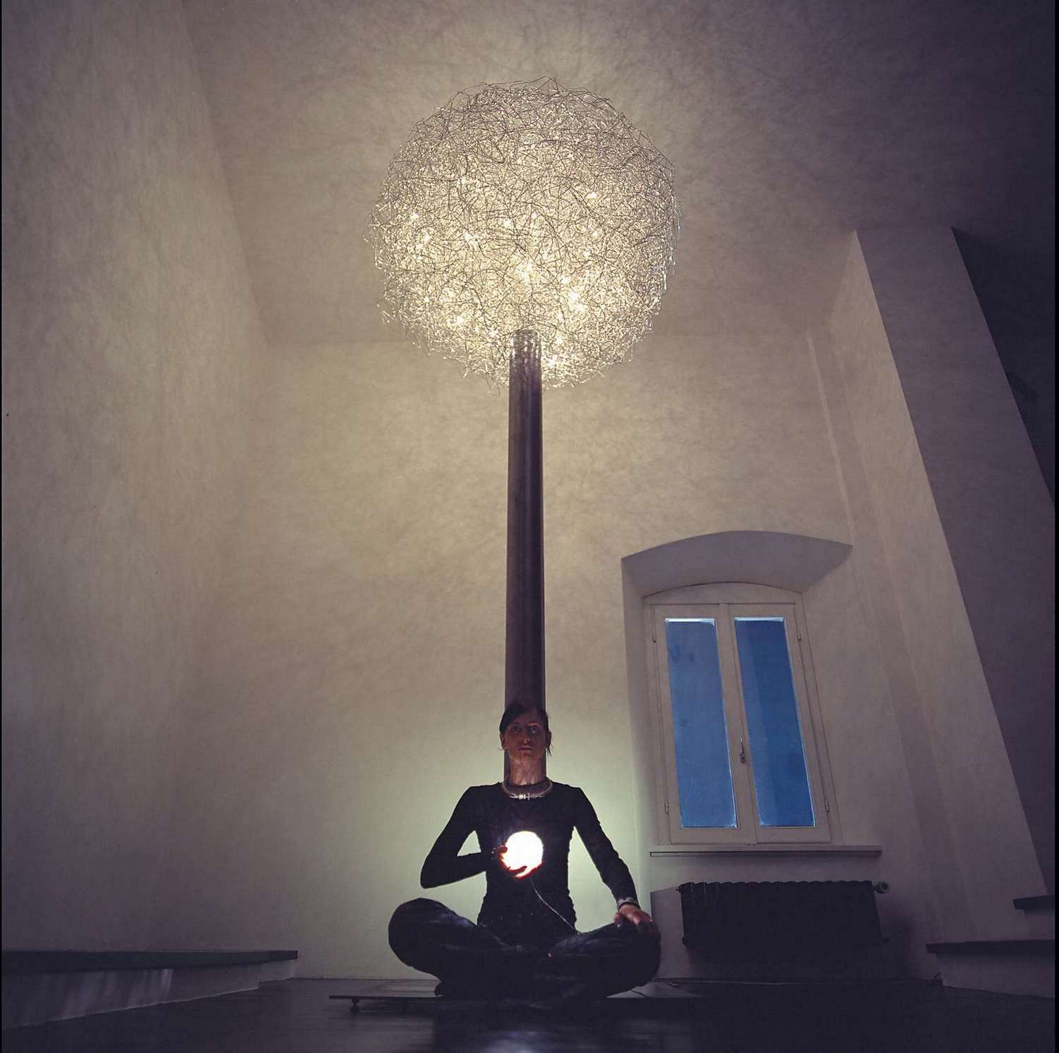 Fil de Fer Hängeleuchte von Catellani & Smith: Drahtkugel-Lampe über einer meditierenden Person. Design Hängelampe.