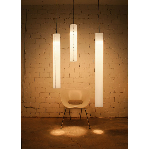 Drei moderne LED Pendelleuchten in Weiß, hängen über einem Stuhl vor einer Backsteinwand.