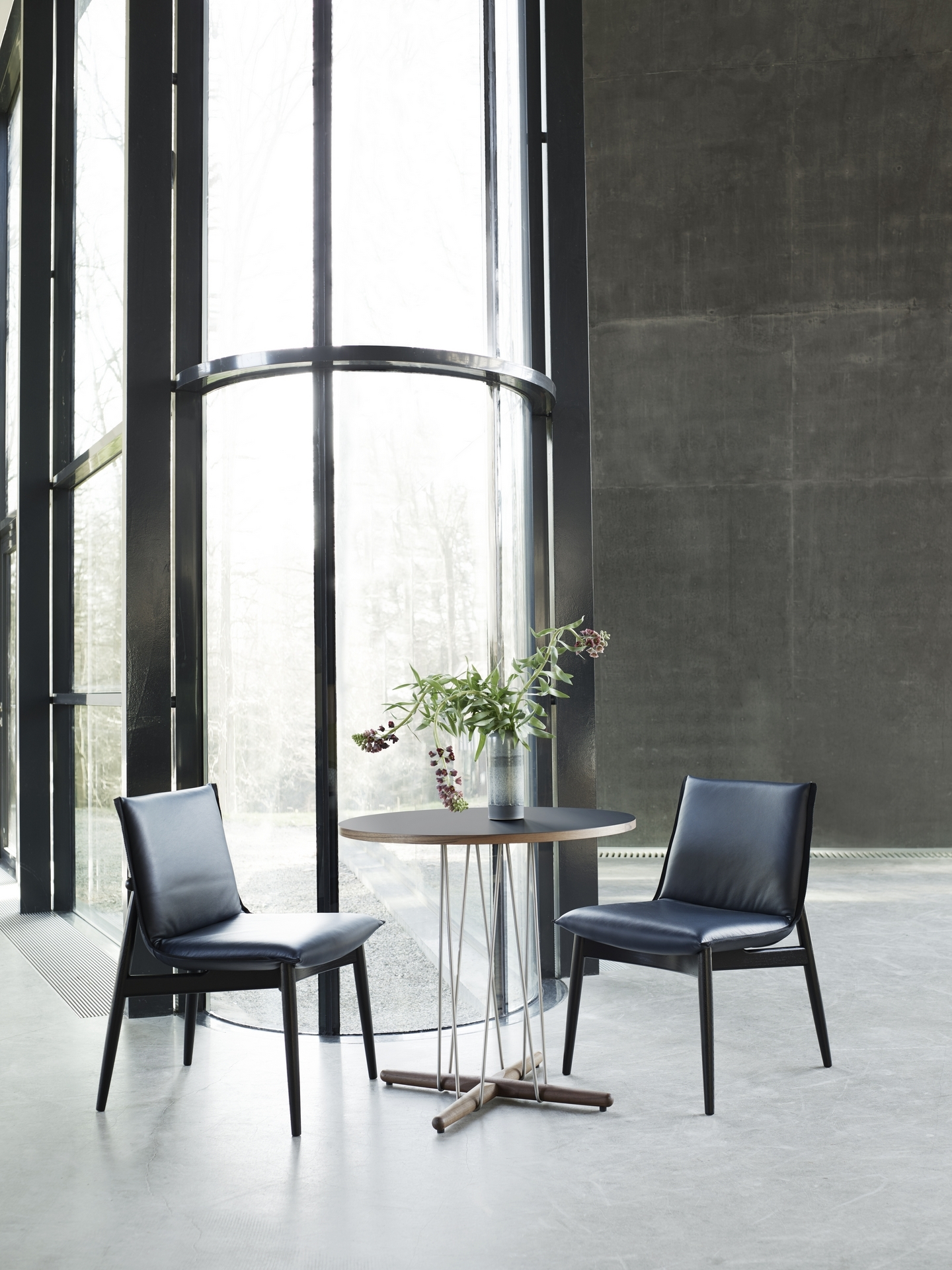 E020 Embrace Tisch von Carl Hansen & Søn mit zwei Stühlen in modernem Ambiente.