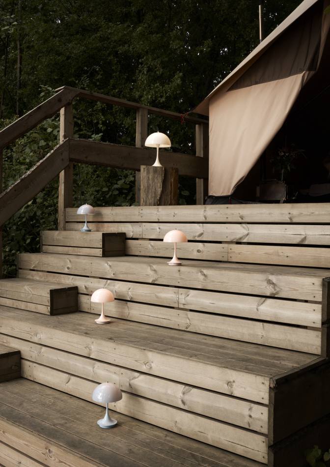 Panthella Tischleuchten in Opal und Rosa auf einer Holztreppe, stimmungsvolle LED-Beleuchtung.