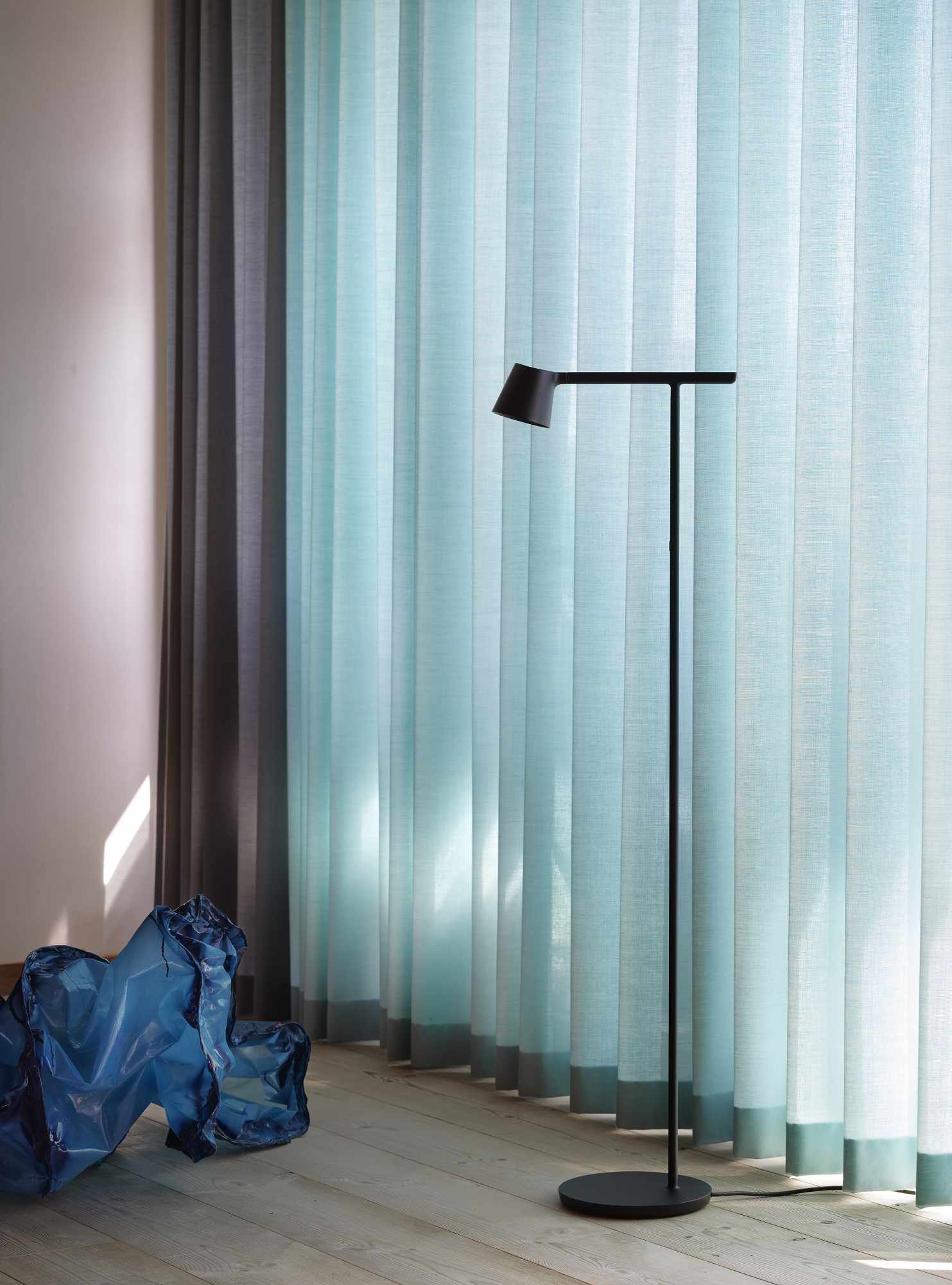 Graue Tip Floor Lamp Stehleuchte von Muuto im modernen Wohnzimmer mit Vorhängen und Kunstobjekt.