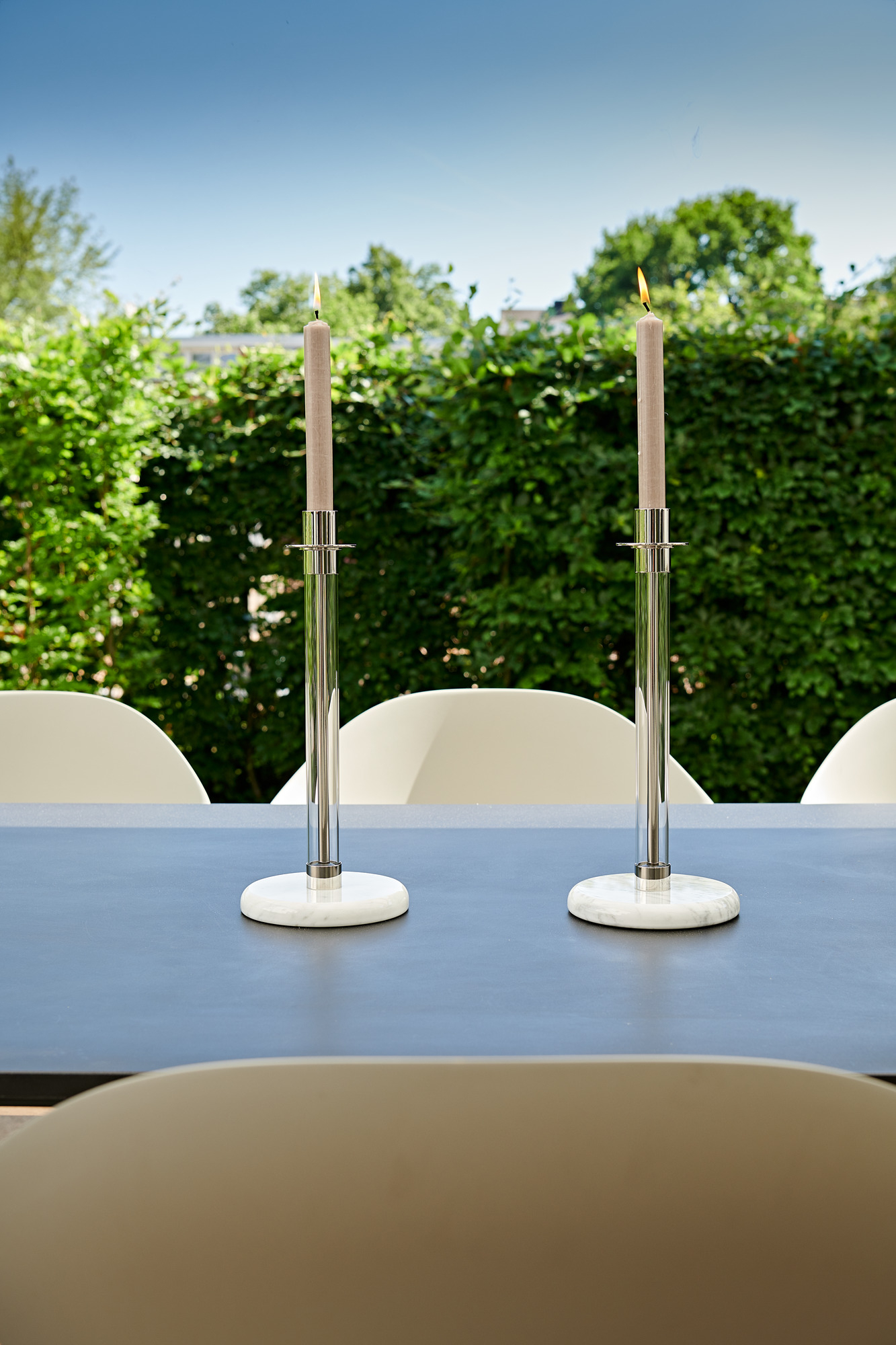 Zwei SL 30 Bauhaus Sabbatleuchter von Tecnolumen aus Onyx mit brennenden Kerzen auf Tisch.