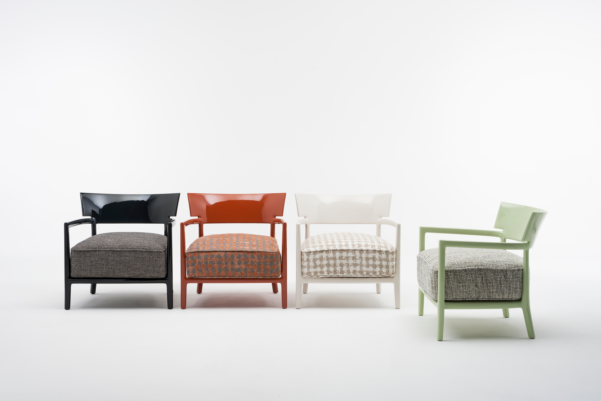 Cara Sessel: Vier moderne Design-Sessel in Schwarz, Rostbraun, Weiß und Grün mit Stoffbezug.