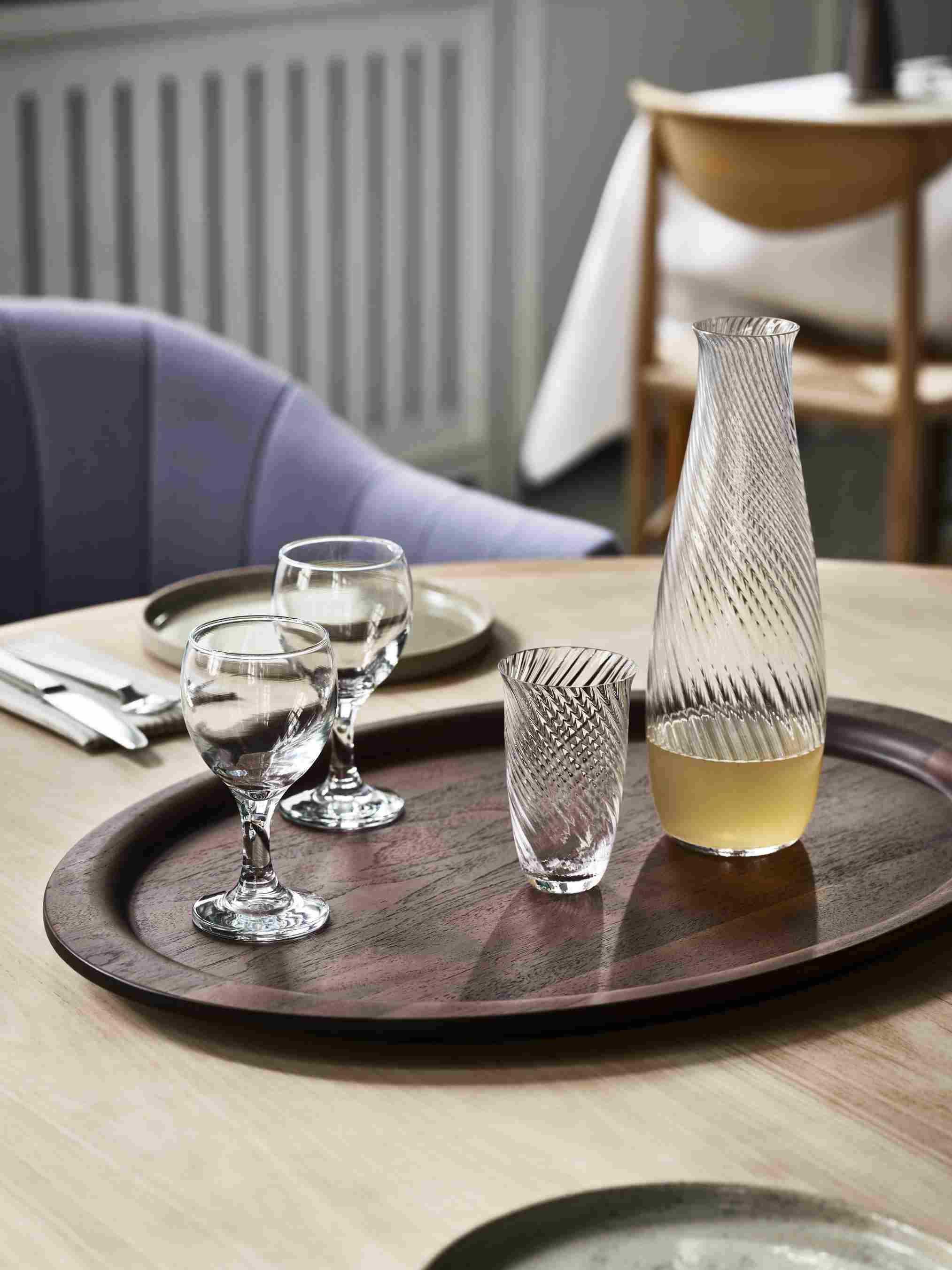 AndTradition Tray SC64-SC65: Ovales Holztablett mit Gläsern und Karaffe auf einem Tisch arrangiert.