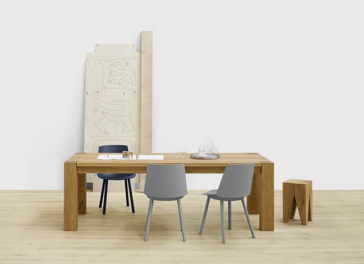 E15 Bigfoot Tisch aus Eiche mit Stühlen und Hocker in minimalistischem Interieur.
