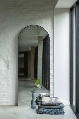 Ethnicraft Gate Bodenspiegel: Klarer, rahmenloser Spiegel in Bogenform, stehend im modernen Interieur.