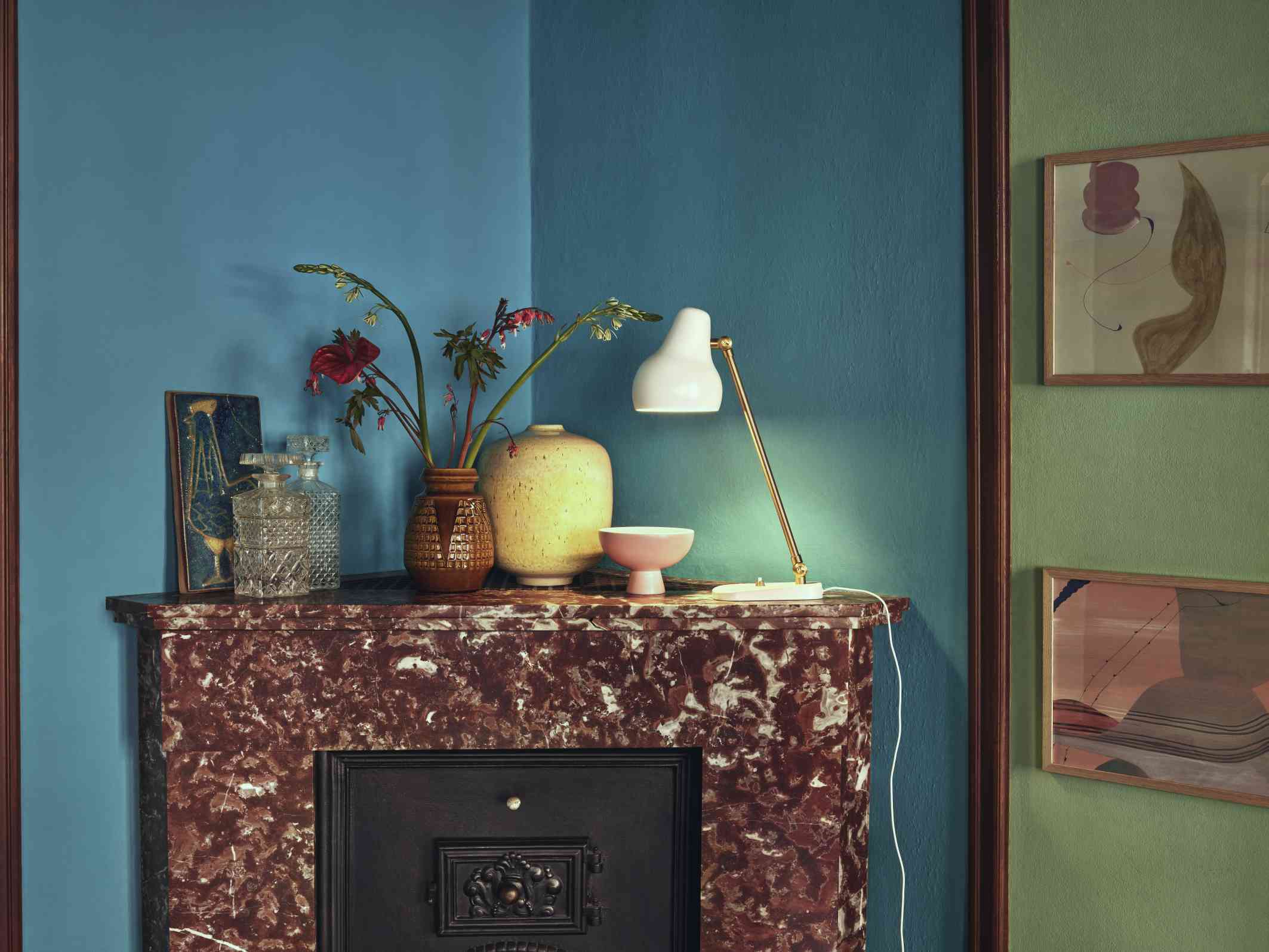 Nahaufnahme der VL38 Tischleuchte von Louis Poulsen in Weiß auf einem Marmorkamin mit Dekoration.