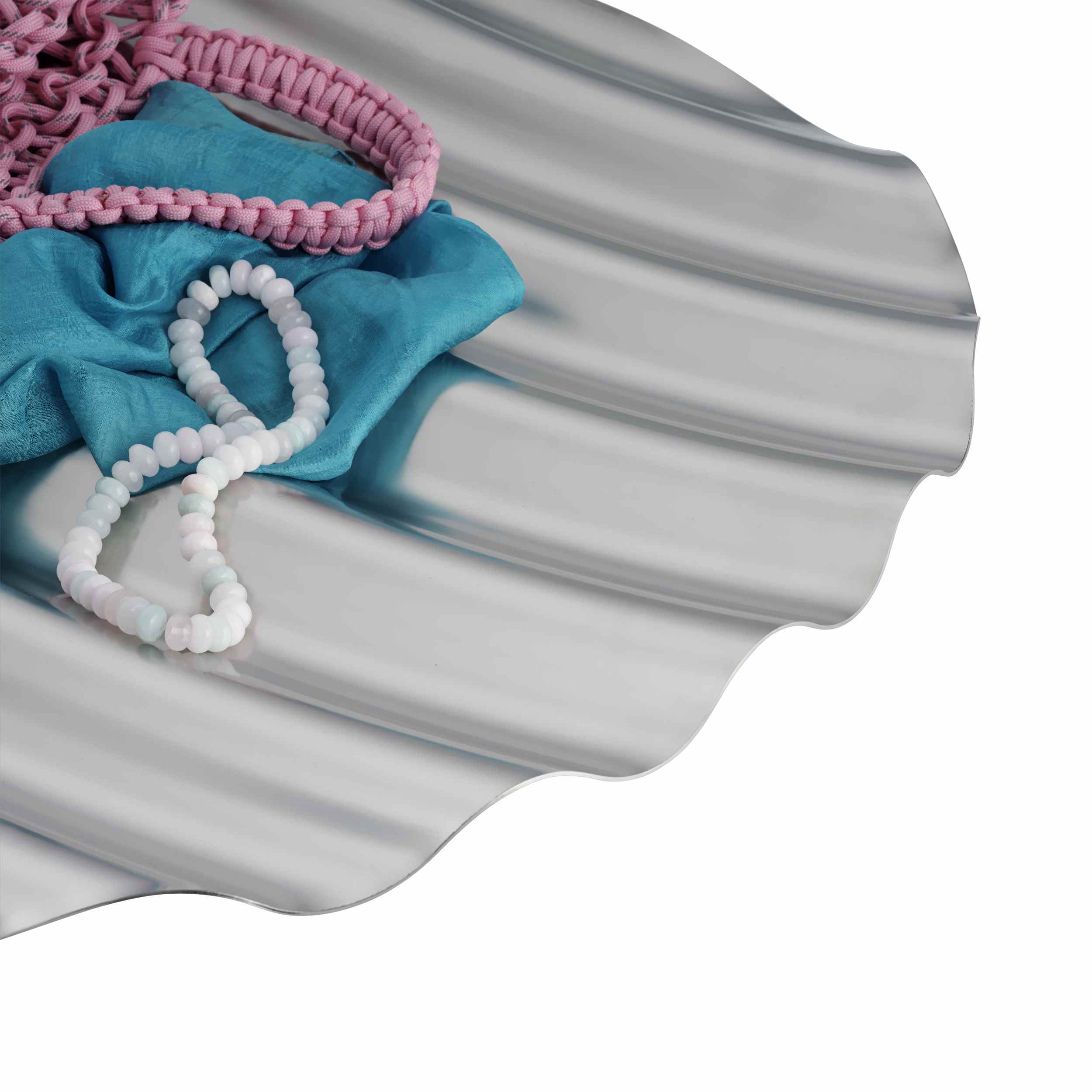 Muuto Wave Tray Schale EINZELSTÜCK: Silberne Design Schale mit wellenförmiger Struktur, dekoriert mit Schmuck und Tuch.