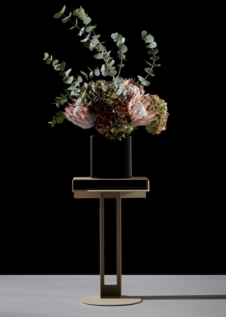 Meta Side Table Beistelltisch New Tendency mit Blumenarrangement in dunkler Vase, modernes Möbeldesign.