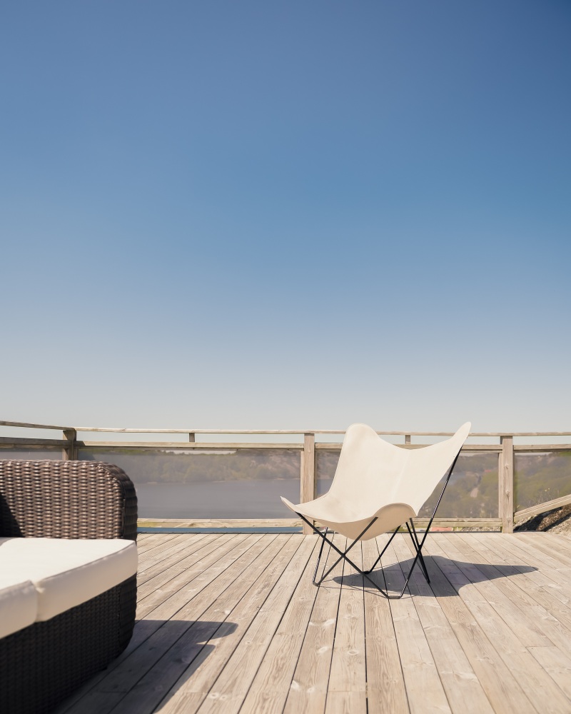 Mariposa Butterfly Chair Outdoor Sessel aus Leder auf Holzterrasse mit Sofa.
