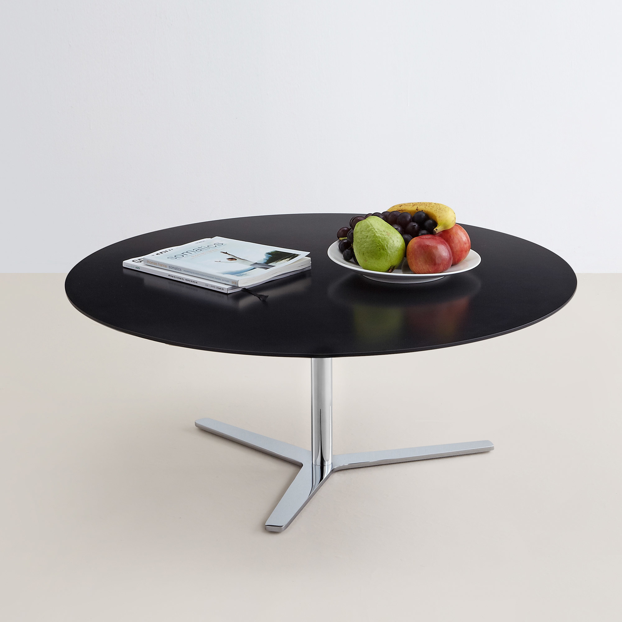 Schwarzer Tre90 Couchtisch von Mox mit Chromfuß, dekoriert mit Obstschale und Magazin. Moderner runder Wohnzimmertisch.