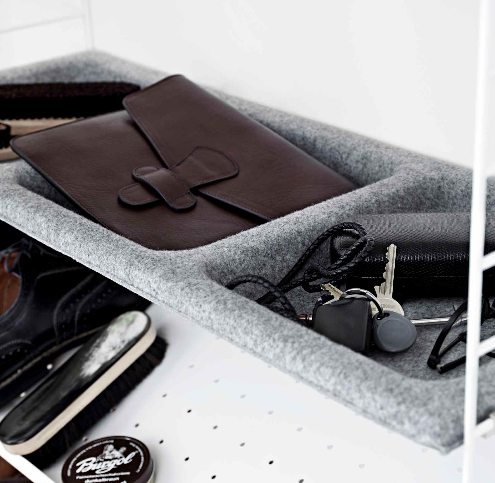 String Sideboard: Grauer Filzeinsatz mit Ledermappe, Schlüsseln und Schuhputzzeug für Schlafzimmer Ordnung.