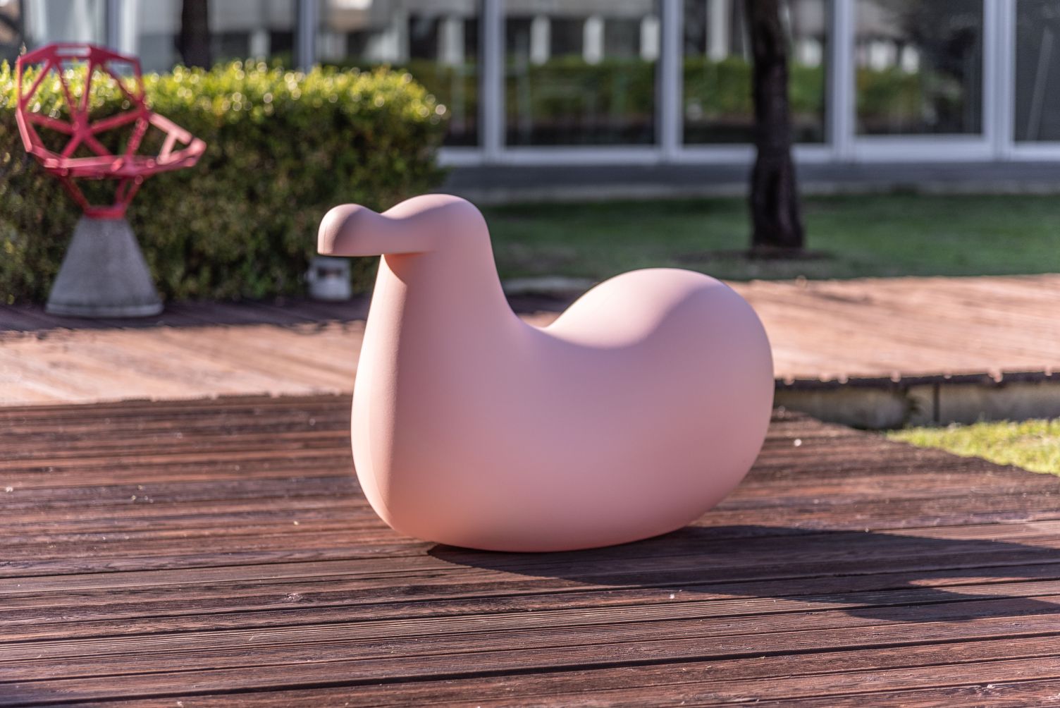 Rosa Dodo Schaukelvogel von Magis für Kinder, modernes Design, auf Holzterrasse.