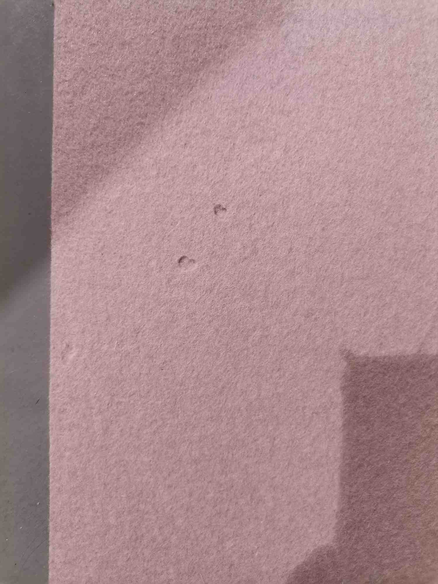 Detailaufnahme des puderfarbenen Hey Sign Teppichs (Mängelexemplar) 140x200 cm mit kleinen Fehlstellen im Filz.