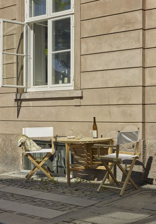 Selandia Klapptisch Ø 94 von Skagerak: Runder Outdoor-Tisch mit zwei Klappstühlen und Wein.