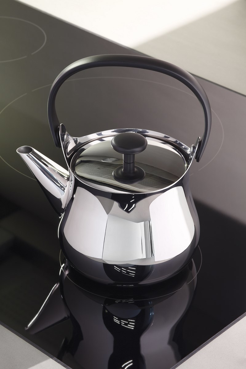 Nahaufnahme der glänzenden Alessi Cha Teekanne NF01 auf einem schwarzen Induktionskochfeld.