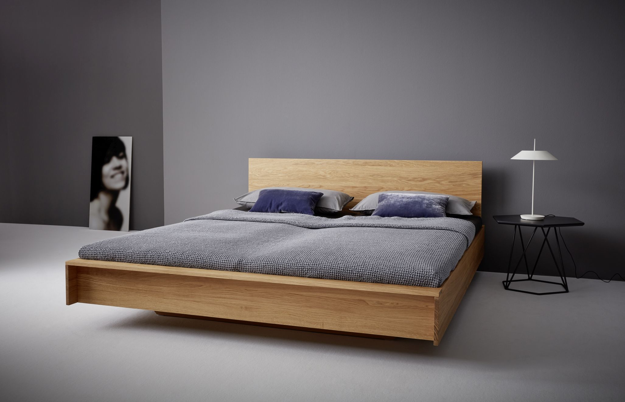 Flai Bett Eiche: Modernes Doppelbett aus Eiche mit Nachttisch und minimalistischem Design.