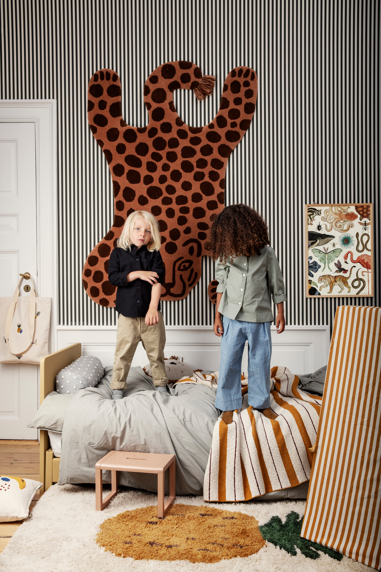 Kinderzimmer mit Ferm Living Safari Teppich Leopard an der Wand und weiteren Teppichen.