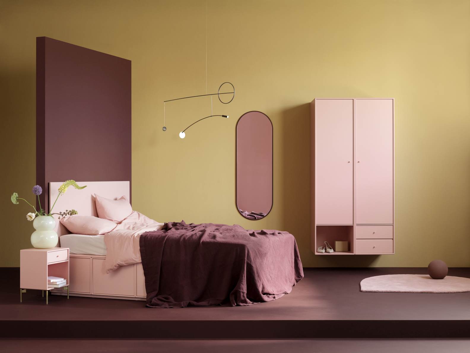 Ovale Colour Frame Spiegel Figur Montana Oyster in rosa Schlafzimmer-Szene mit Bett und Schrank.