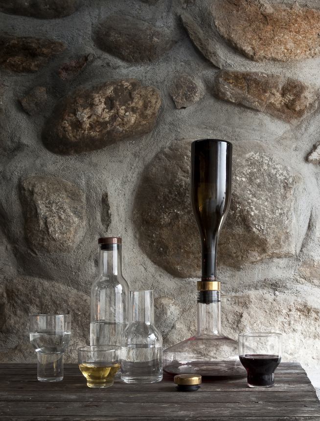 Audo Wine Breather Karaffe mit Dekantieraufsatz und Gläsern vor rustikaler Steinwand.