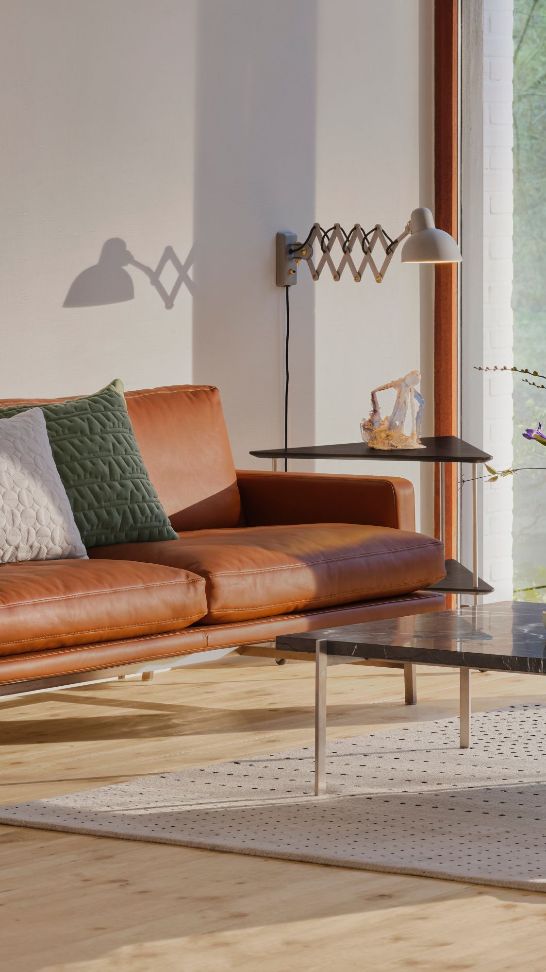 6718 Scherenleuchte KAISER idell Easy grey an Wand über Ledersofa im Wohnzimmer.