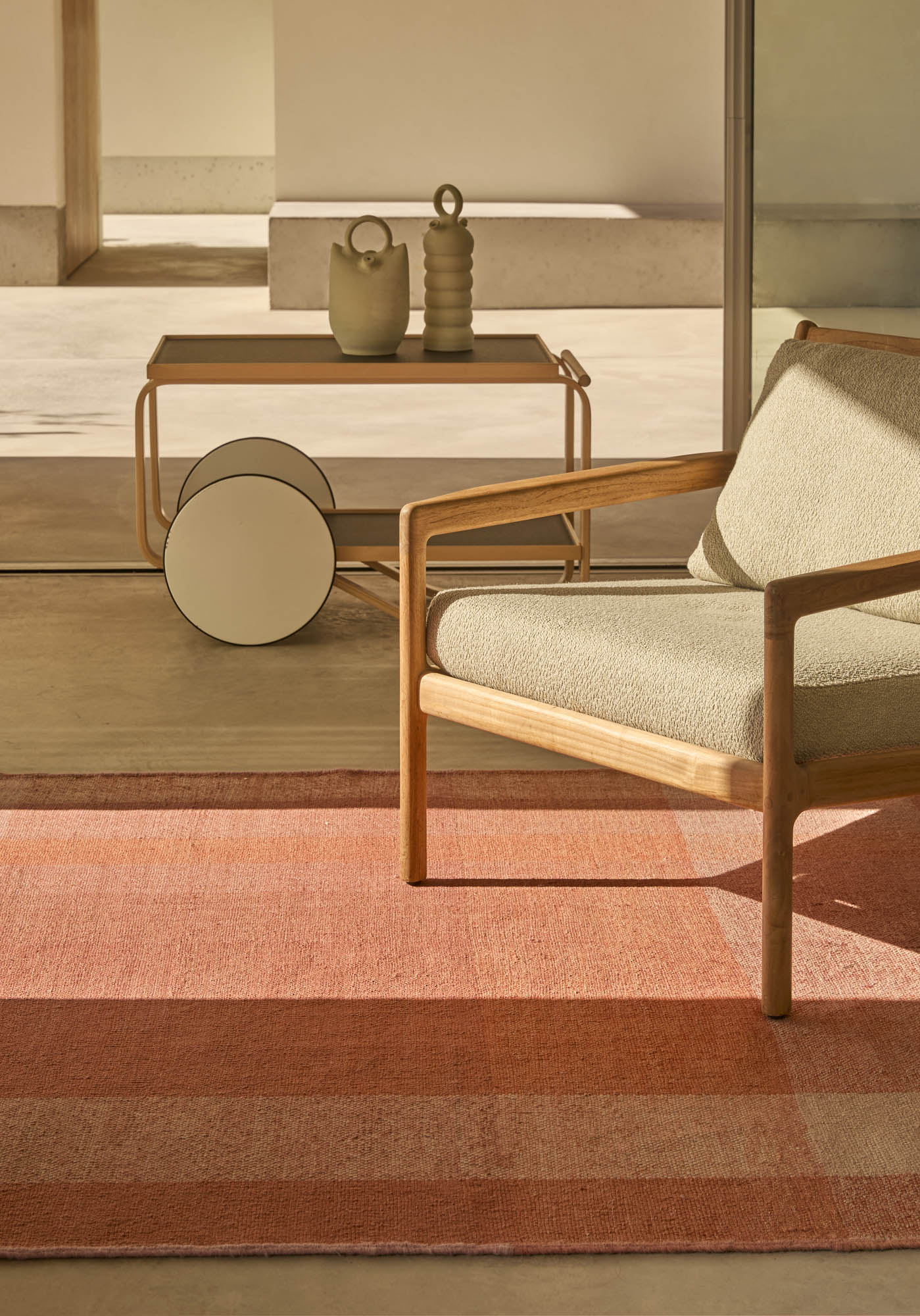 Nahaufnahme des Nanimarquina Teppichs "Nuance" in Lime mit Streifenmuster, kombiniert mit Holzmöbeln.