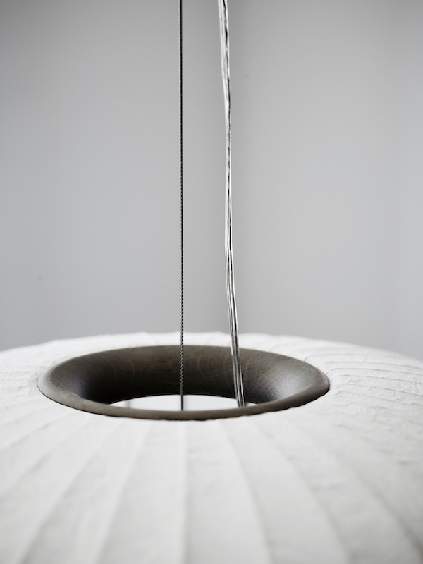 Detailaufnahme der Vipp Paper Pendant Pendelleuchte mit dunklem Eichenholzring und Papier Lampenschirm.