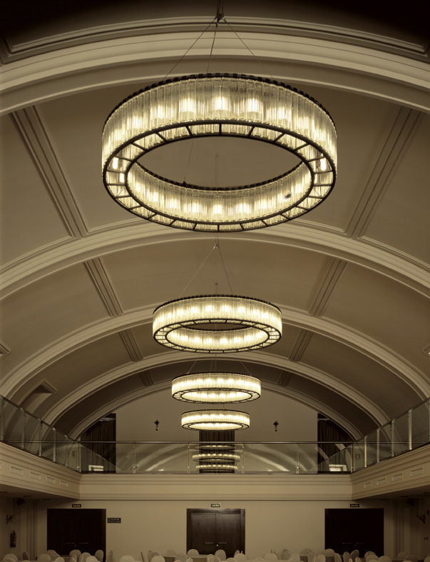 Estadio 105 Deckenleuchter von Santa & Cole: Mehrere runde, moderne Deckenleuchten in einem Saal.