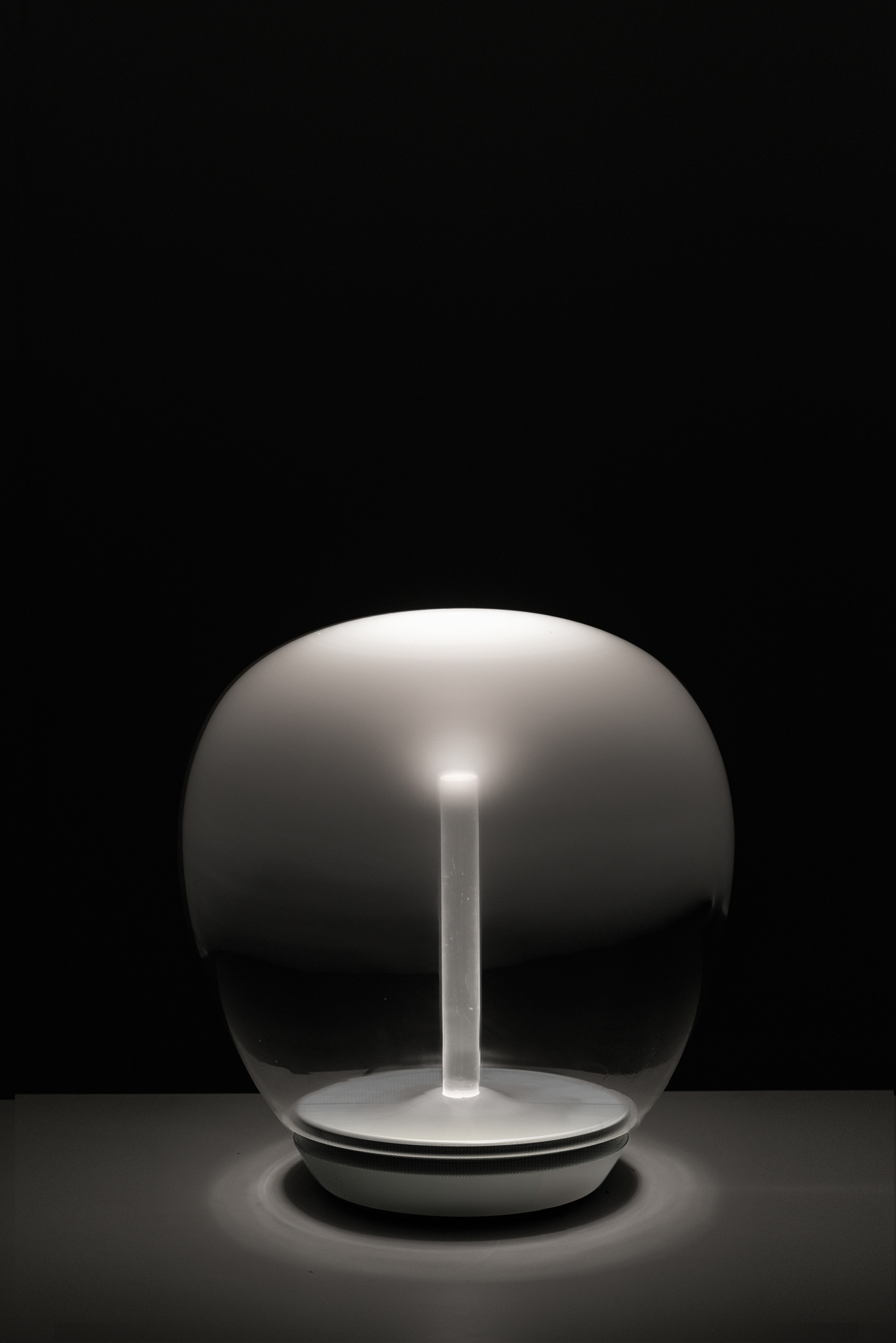 Nahaufnahme der Artemide Empatia Tischleuchte: Glas, Licht, modernes Design, stimmungsvolle Beleuchtung.